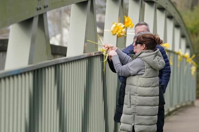 Nicola Bulley's sister, Louise Cunnigham (front), with her mother and father-in-law, ties a yellow ribbon to a bridge over the River Wyre (Credit: Peter Byrne/PA Wire)