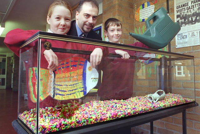 Grange Park Junior School pupilsSarah Silverwood (9) and Neil Green (10 ) start to fill up the school's new aquarium, which had been donated by Focus Do it All. Also pictured is the store's branch manager Paul Crossley