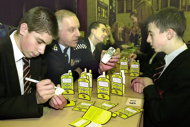 Postcoding and noting of IMET numbers on mobile phones, at Millfield High School, Thornton. Matthew Banks (right) has his phone postcoded by fellow pupil Nick Green. Also pictured is PC Keith Williams, 2003