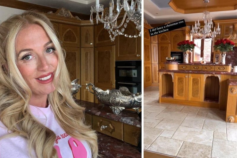 Matching wooden cupboards are paired with marble worktops, tiled floors and a large chandelier