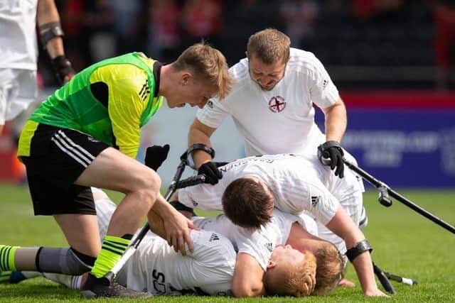 England teammates congratulate goalscorer Jamie Oakey (on his back) in Poland