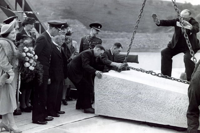 The King and Queen watch a casket of mementoes being placed under the huge blocks of stone forming the spillway at Ladybower Dam after the opening in September 1945