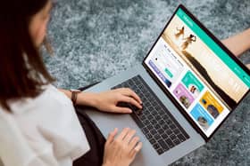 A lady sat using a laptop to book a holiday.