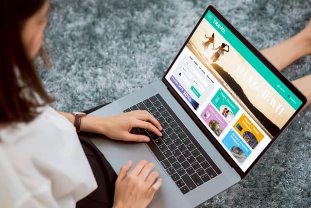 A lady sat using a laptop to book a holiday.