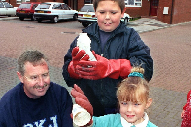 Three year old Nicola Camming helps Adam Brown (10) and estate manager Stephen Wardle clean up some of the litter in Chatburn Close, 1999