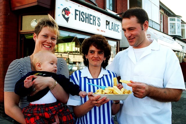 Champion chippy owner David Seamark, who ran the Fisher's Plaice chip shop on Westcliffe Drive, Layton Blackpool. Pic shows David's 7 month-old son trying to pinch a chip, together with Donna Seamark (left) and shop manageress Karen Taylor in 1996