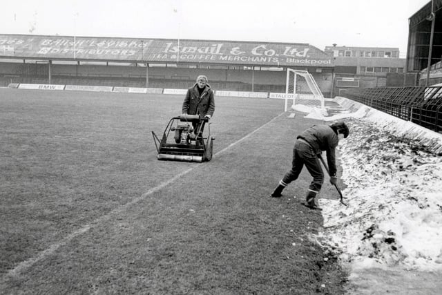 The remaining drifts of snow are cleared away from the surrounding track at Blackpool FC and groundsman Cyril Robinson gives the grass a trim at Bloomfield Road, in readiness for the return of soccer in 1981