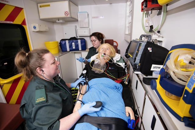 Amy Ball and Emily McNestrie practice on a dummy in the back of ambulance simulator.