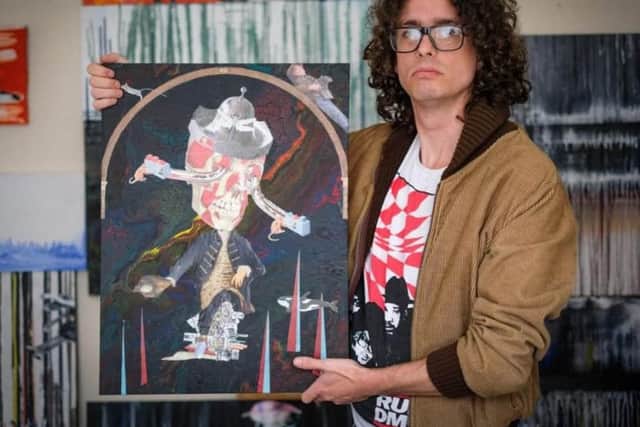 Mathew Jones, a recovering addict who now helps others with art therapy, holding one of his paintings at a former art exhibition.