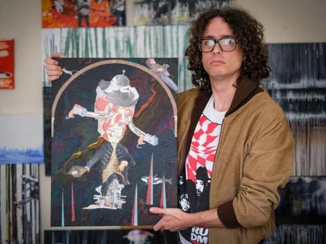 Mathew Jones, a recovering addict who now helps others with art therapy, holding one of his paintings at a former art exhibition.