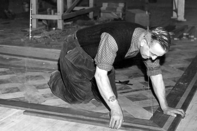 A craftsman fitting the new ballroom floor in 1956