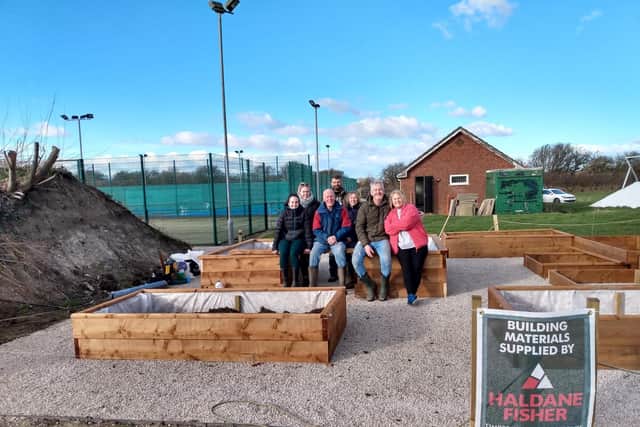Members of HASSRA Fylde and HASSRA Garden Club with the tailor-made raised beds with wood donated by Haldane Fisher Timber Merchants Garstang for children and families of Brian House as well as patients at Trinity Hospice