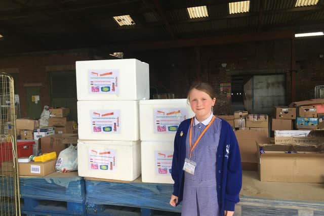 Twizz Lancaster with some of the polystyrene crates containing various bars of chocolate, donated by Over Wyre residents to the refugees from Ukraine