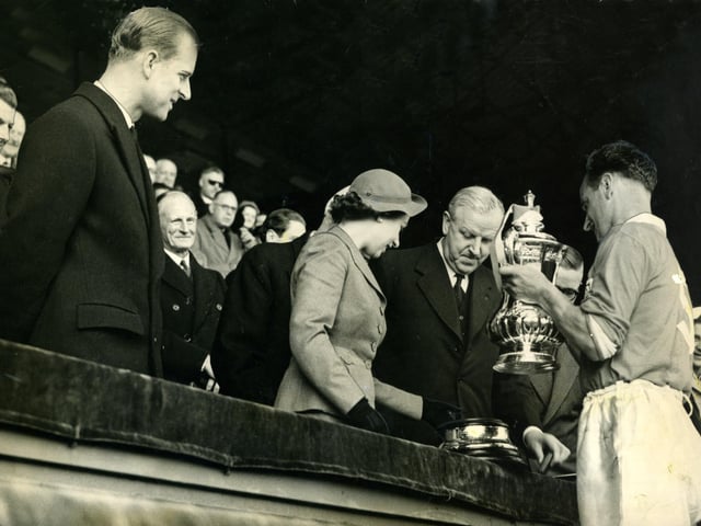The Queen presents the FA Cup to Blackpool captain Harry Johnston, watched by the Duke of Edinburgh and Lord Derby