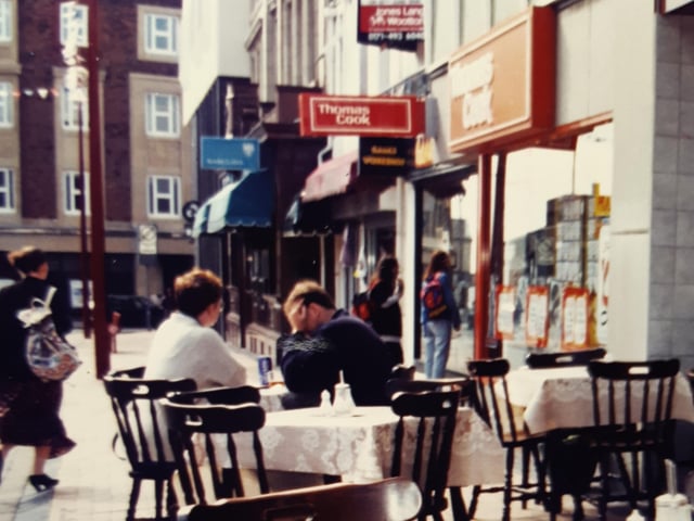 The Coffee Pot and its outdoor tables with Thomas Cook and Barclays Bank beyond in Birley Street