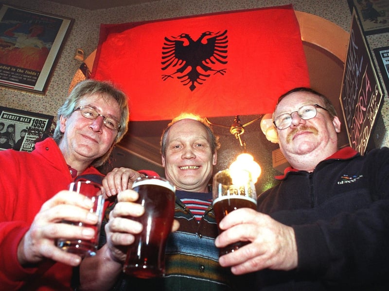 The Wheatsheaf declared itself the first Kosovan Embassy, after regulars travelled to the region with a company building army camps, 1999. Pictured under the Kosovan flag are L-R: pub landlord and Kosovan 'Ambassador' Barrie Eastwood, and 'envoys' Ian Bootham and Syd Marshall