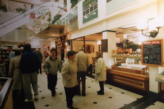 People browsing the stalls inside. An ice-cream menu pinned to the wall to the right and in the distance personalised rock was on sale