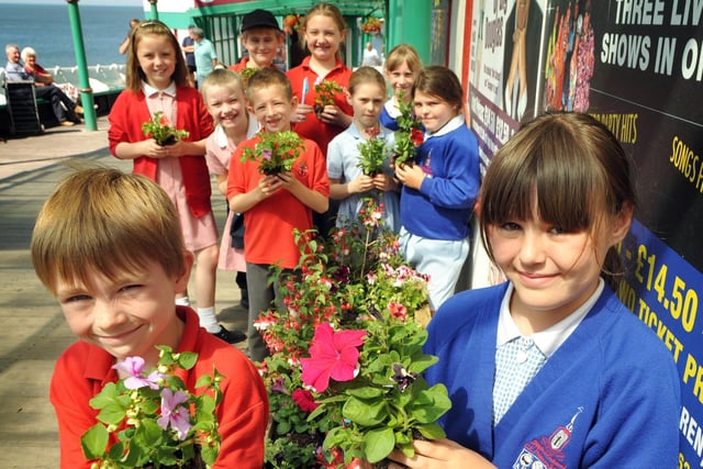 Jacob Smith (left) and Molly McLellan (right) with pupils from St Johns Primary School and Bispham Endowed Primary School planting on Blackpool's North Pier