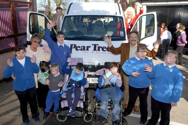 David Howarth presenting the keys of a new minibus to headteacher Jean Cook, accompanied by pupils from Pear Tree School, county councillor Niki Penney and comedian Bobby Ball, patron of the school