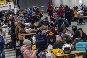 People wait in the reception centre for refugees from Ukraine at the main train station in Berlin, Germany on Sunday