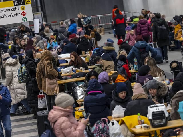 People wait in the reception centre for refugees from Ukraine at the main train station in Berlin, Germany on Sunday