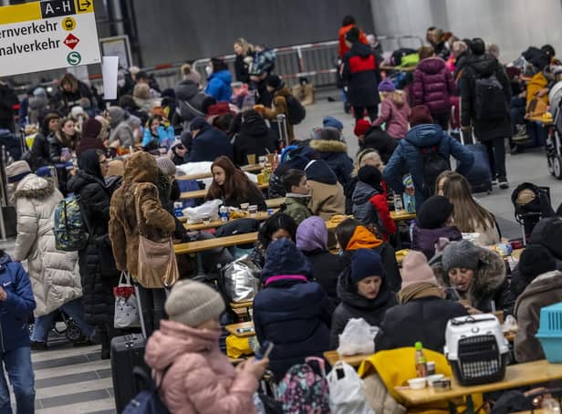 People wait in the reception centre for refugees from Ukraine at the main train station in Berlin, Germany on Sunday