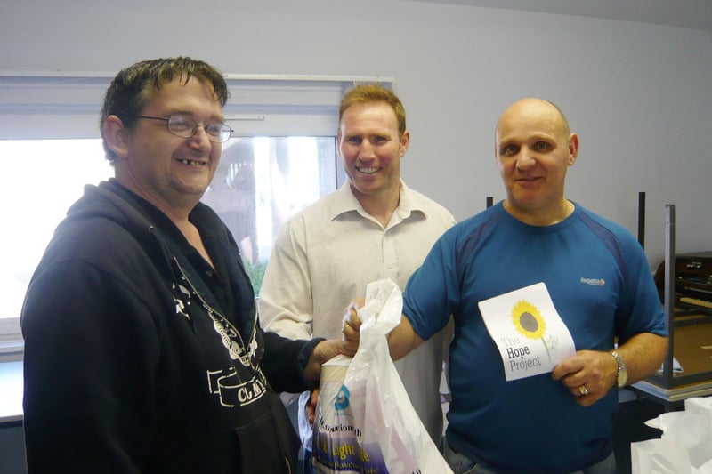 Stephen Fisher with Steve Preyzner and Franco Bellusci from The Hope Project handing out food parcels in the Queenspark flats