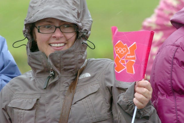 A spectator waves a flag as the Olympic torch made its way along the Esplanade in Fleetwood