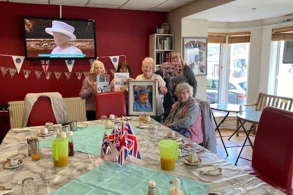 Members of the Claremont First Steps Community Centre social clubs with their portrait of the Queen
