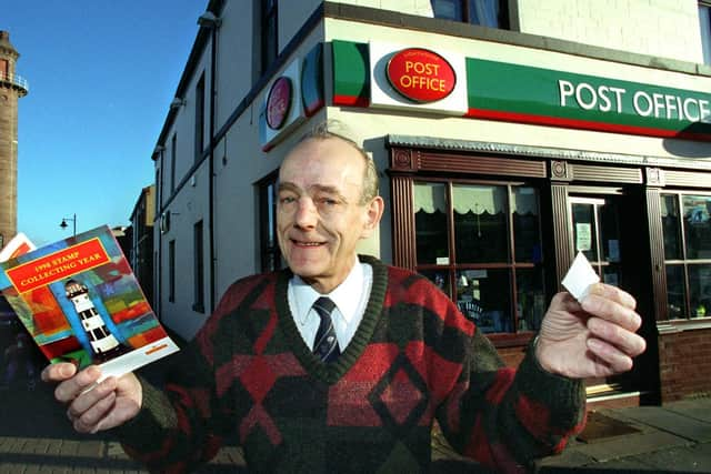 Derek Eaton gives the stamp of approval to the new  Royal Mail Lighthouse stamps. Pictured behind is his Post Office and the Pharos St. lighthouse, at Fleetwood.