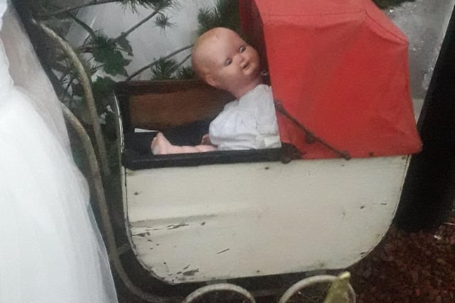 This baby doll in a vintage pram is more creepy than sweety!