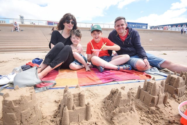 Carla, Leo, Jonah and Matthew Moore soak up the sun on the sand in front of Blackpool Tower.