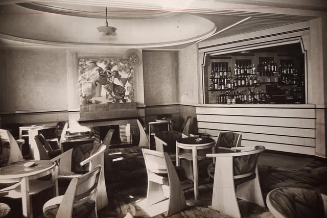 The caption the back of this 1936 photo says 'The new lounge on the first floor of the Palatine Hotel is furnished in sycamore.' Allegorical panels crown the fireplaces