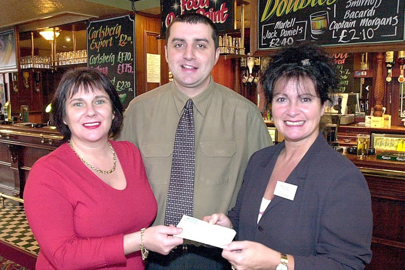Mere Park Hotel landlady Jackie Higginbotham (left) and regular Dominic Woodhouse present a cheque to Macmillan Windmill Appeal Co-ordinator Karen Dyke, following a fundraising event in 2001
