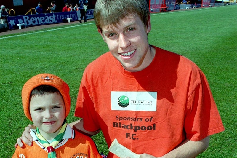 Paul Arkwell shares a sandwich with Blackpool player John Hills during a picnic at Bloomfield Road