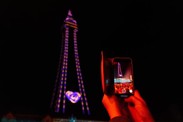 A visitor takes a photo of the tower as the illuminations are switched on for 2023.  Photo: Kelvin Lister-Stuttard