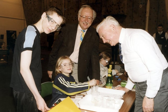National TV Weatherman Michael Fish visits the BNFL experiment stand at the Arnold School, Blackpool, Eureka 2000! exhibition. Robert Brown (left) and Alex Vann (seated) try out a chemistry experiment on the BNFL stand watched over by Michael Fish (centre) and Steve Corrin, from BNFL