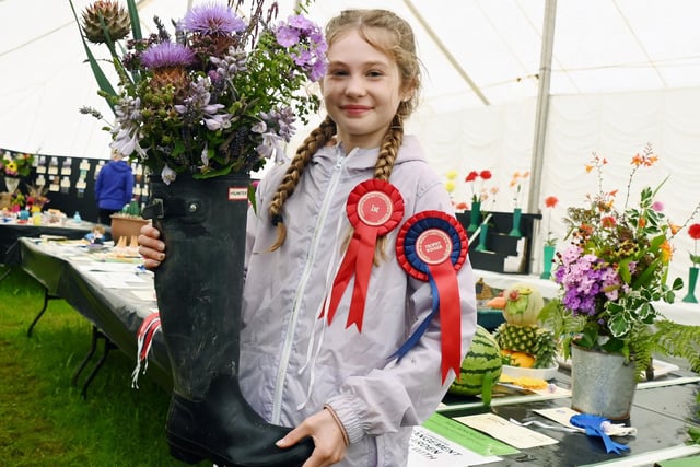 Freya Burton, 11, with her award-winning floral display in a wellington boot