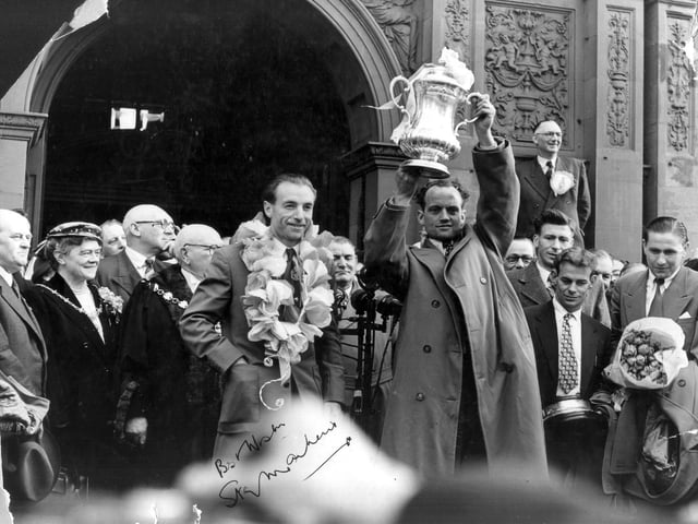 Wearing a victor's garland Stanley Matthews stands with Harry Johnston outside the Town Hall