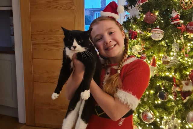 Emily, age 10, shares a Christmas cuddle with Sweep the cat, age 12.