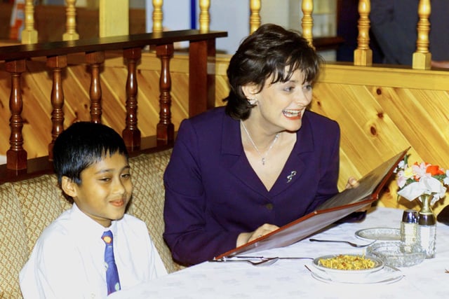 Cherie Blair laughs as she chooses an Indian take-away meal for 20 people with the help of nine-year old Shuhel Miah, the son of the manager of the Sunam Curry restaurant in Blackpool