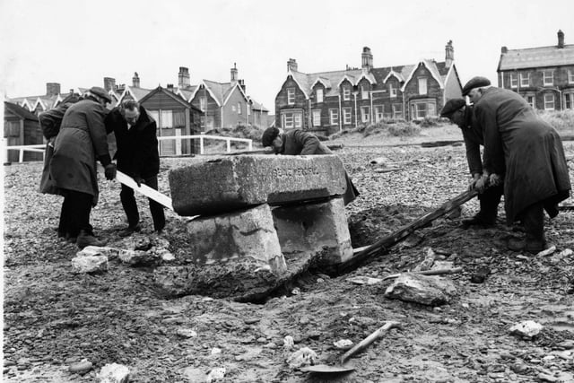 It took a lot of manpower in January 1974 to remove the horse trough, which was a well known landlmark on St Annes beach, north of the Pier . Behind stand the wooden beach chalets which have long since gone