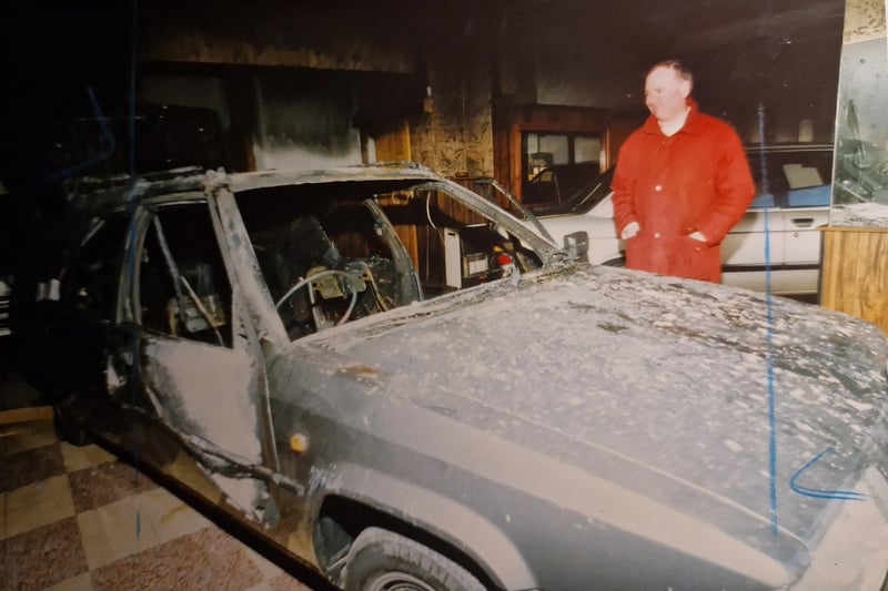 Mike Tudor of Tudo car sales, looking at a burned out Citroen following a fire bomb placed in the car while it was parked on the forecourt