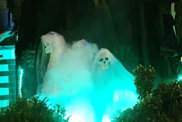 Spooky creatures are lit up in green and covered by a smoke machine