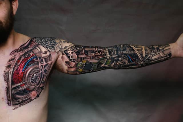 Warwick, a client from Canada, showing off his finished biomechanical tattoo after a session with Shamack.