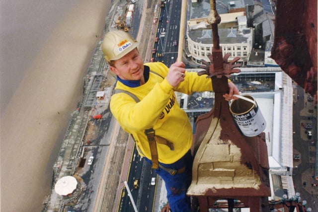 Rigger Mark Smith puts the first touch of gold on the very top of the Tower for  Blackpool Tower centenary, 1994