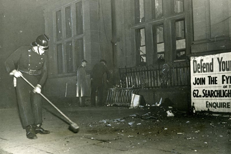 A fireman helps to clear up the damage caused to Blackpool Town Hall by an IRA bomb whilst others make an inspection, 1939