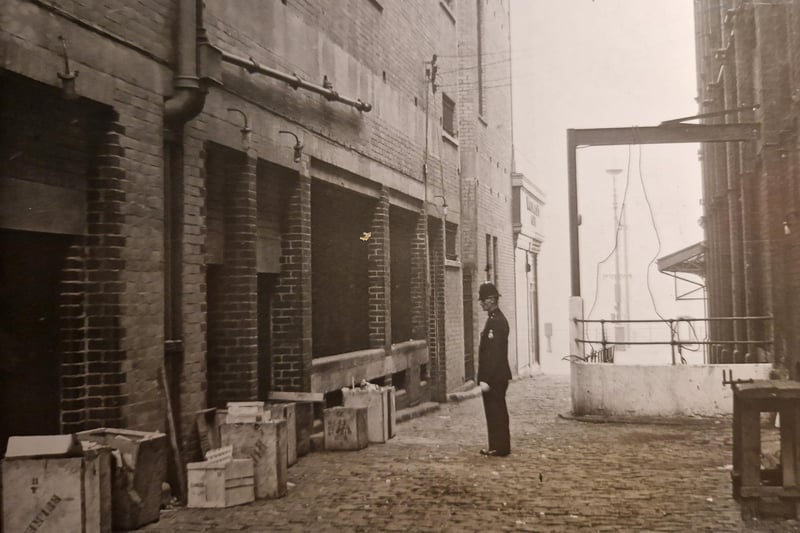 The police officer in this picture is looking at the spot where two bombs were found in a dustbin at the foot of the old Woolworths building in 1939