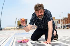 Reporter Richard Hunt prepares to crack an egg on the Comedy Carpet in Blackpool to see if it will fry. Photo: Kelvin Stuttard