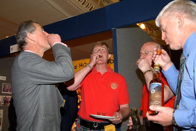 Prince Charles tries a shot of whisky during the Rotary Conference in Blackpool